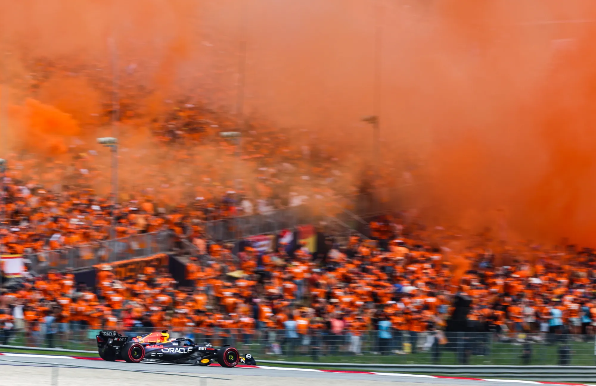 Verstappen driving at the 2023 Austrian GP a sea of orange slowing submerging the track (Image Credit: Red Bull Content Pool)